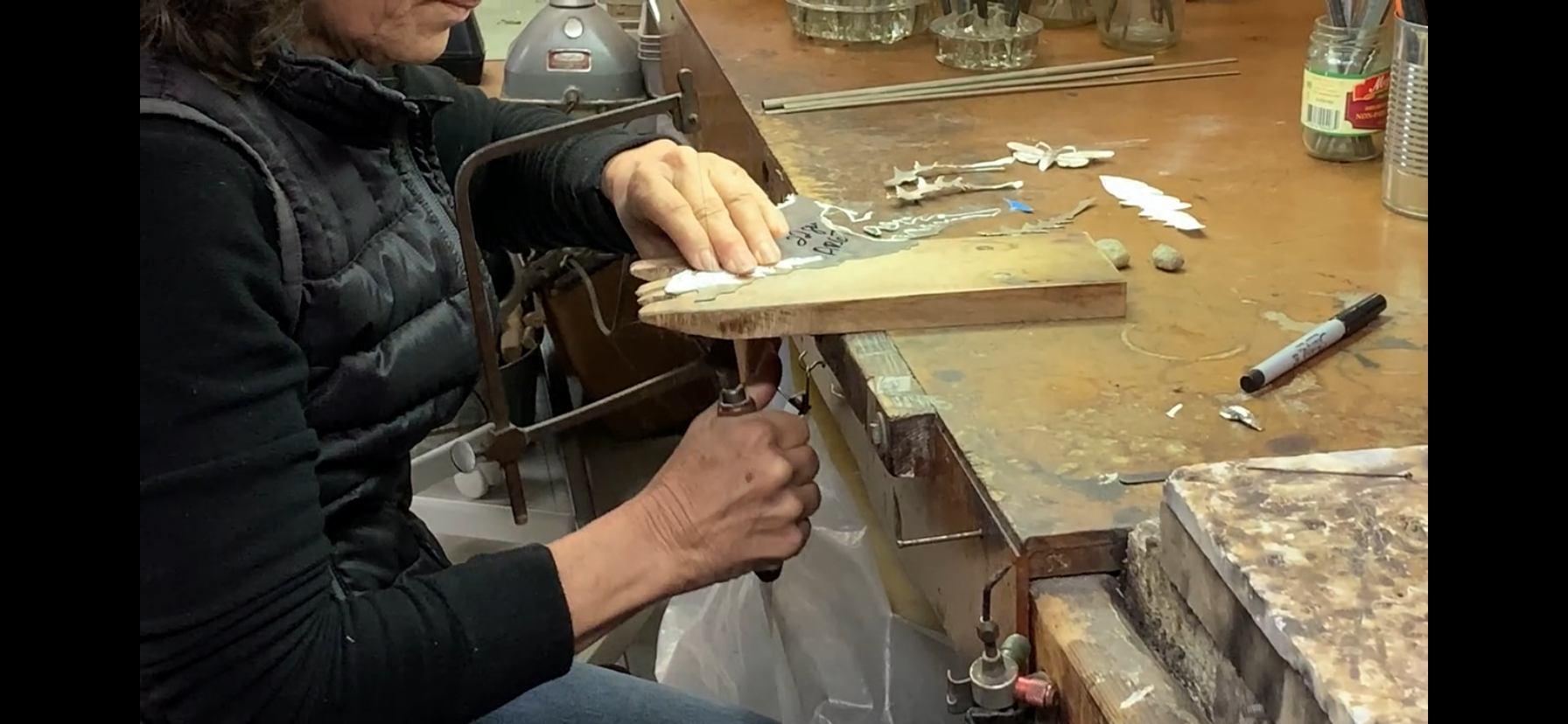 Load video: Robyn Nichols cutting silver in her studio.